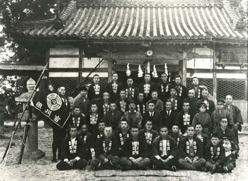 大正10年。旧富松神社前で神主さんと吉川組の代表者、羽織を来た職人達の集合写真。